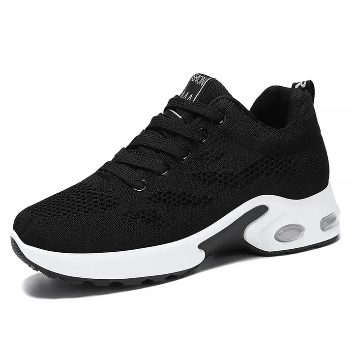 Aerion black breathable knit trainers for women, featuring a white air-cushioned sole and bright pink laces shown from a three-quarter angle.