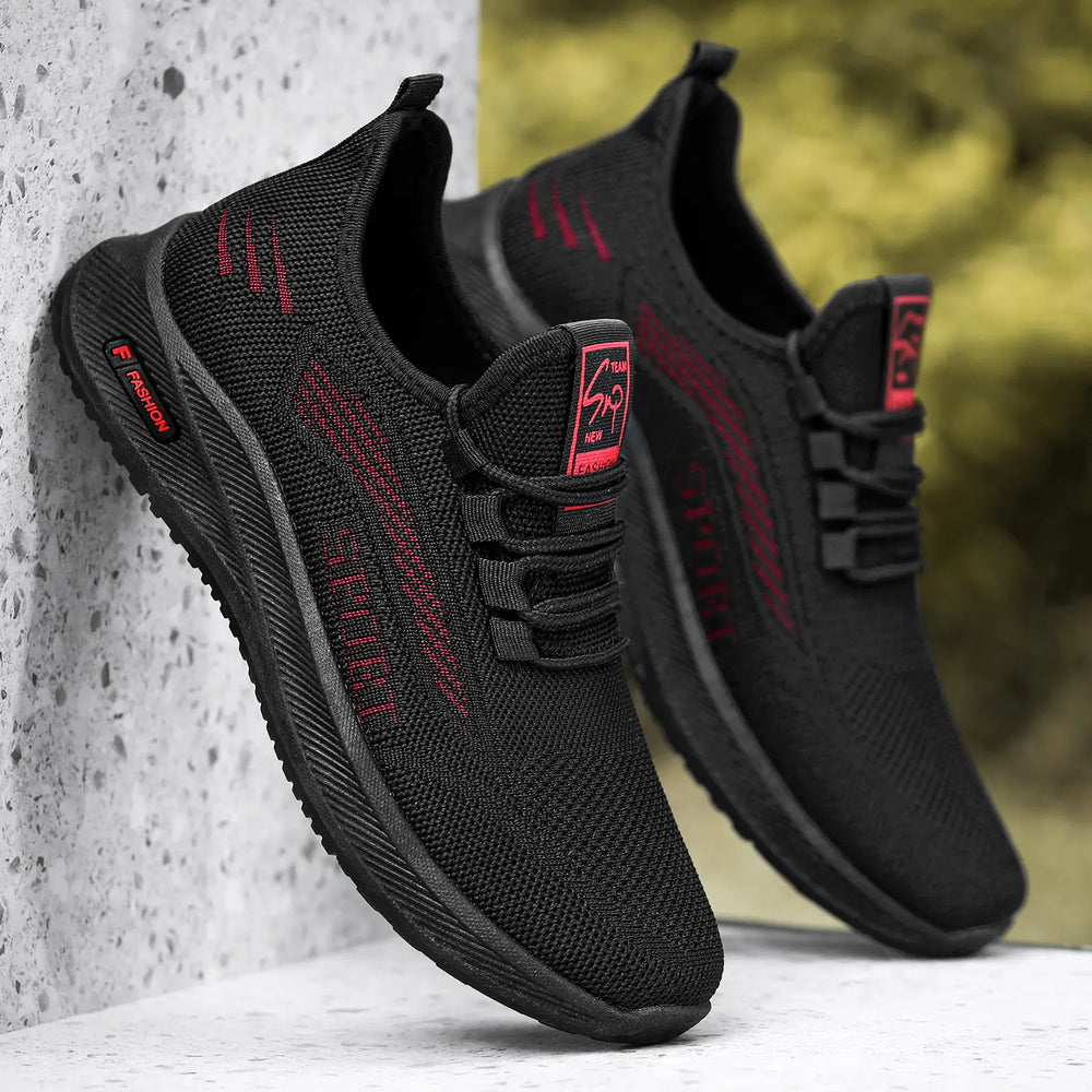 Pair of black Aerlox men's breathable athletic sneakers with red woven accents and 'SPORT' detail, shown at a three-quarter angle with a textured heel tag and rubber sole.