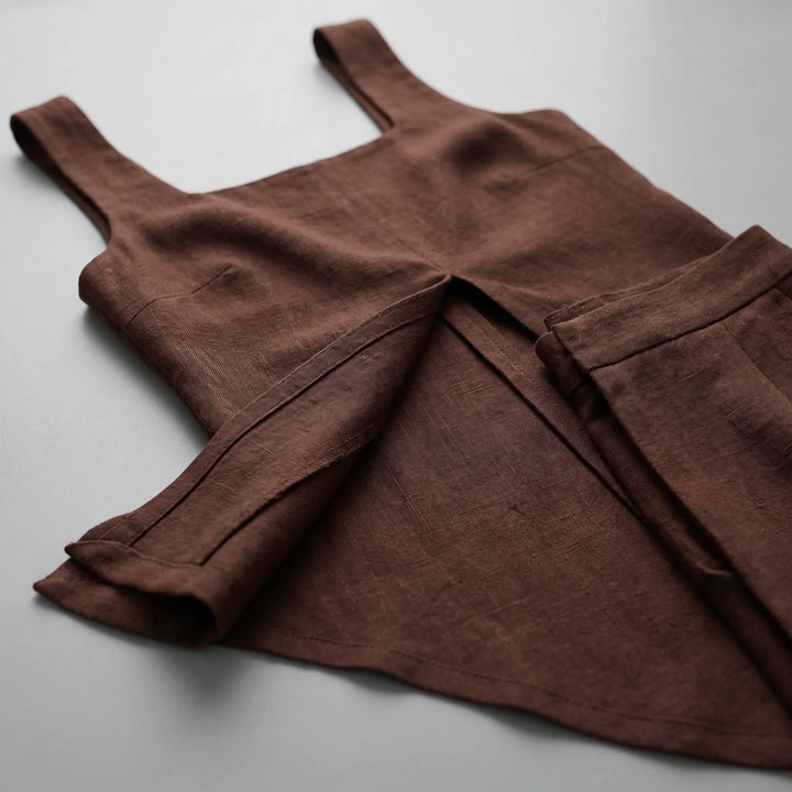 Close-up detail of a dark chocolate brown Arvyla two-piece set, showcasing the matte polyester blend fabric, the flowing front split on the sleeveless top, and the drape of wide-leg trousers.