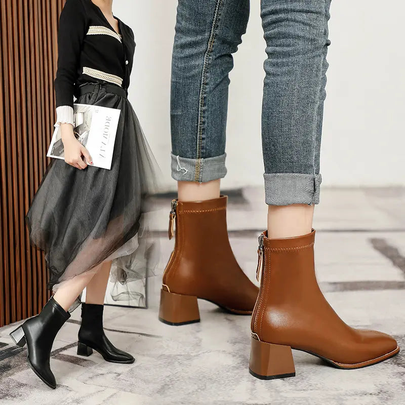 Axorian chic ankle boots in tan and black, featuring a square toe, comfortable block heel, and rear zipper closure, styled with denim jeans and skirts on a textured floor.