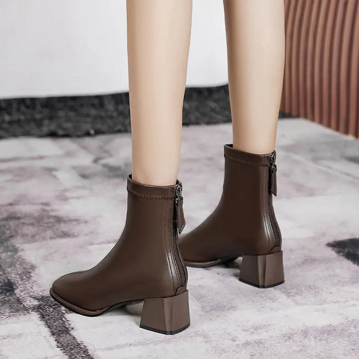 Axorian chic ankle boots in brown faux leather, featuring a square toe, block heel, and rear zipper closure, shown on a model&