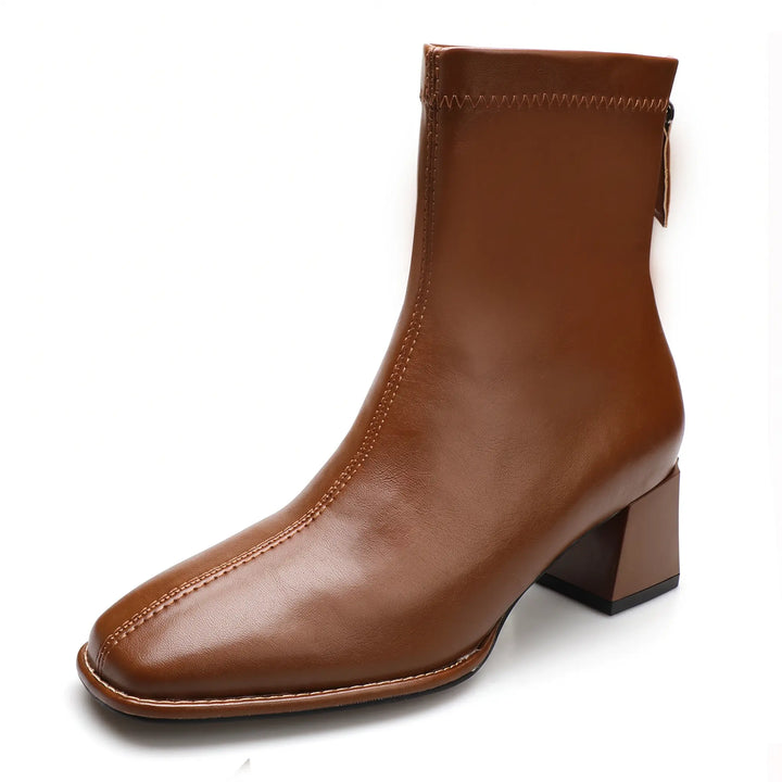 Brown faux leather ankle boots with a chic square toe, stable block heel, and convenient rear zipper closure. Includes a fleece-lined icon for warmth.