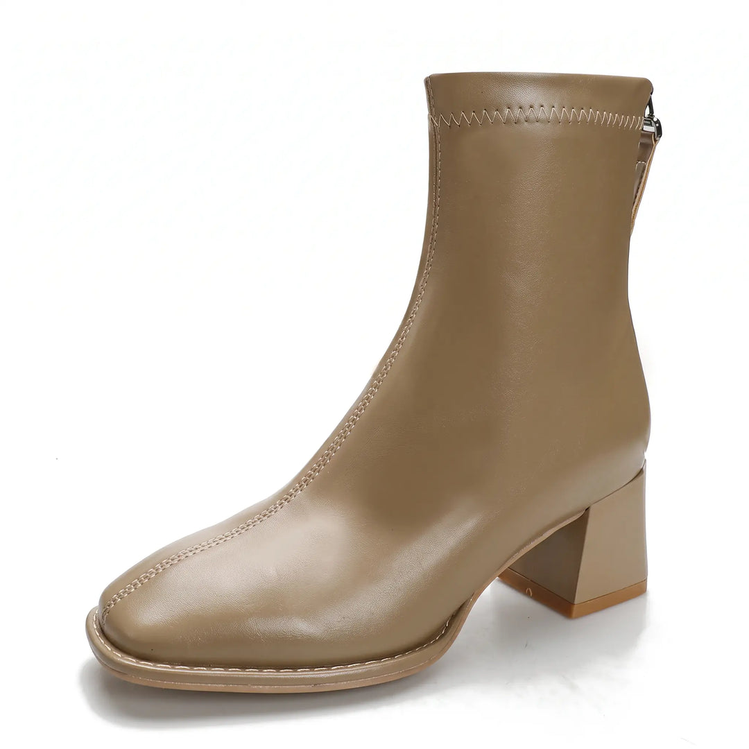 Taupe faux leather ankle boots with a square toe, block heel, and rear zipper, featuring a fleece-lined interior indicated by a graphic overlay.