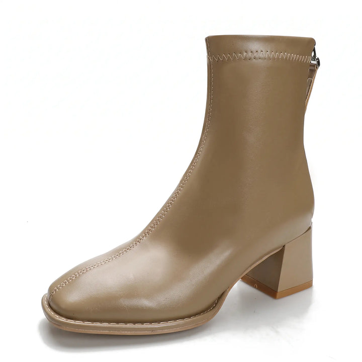 Taupe faux leather ankle boots with a square toe, block heel, and rear zipper, featuring a fleece-lined interior indicated by a graphic overlay.