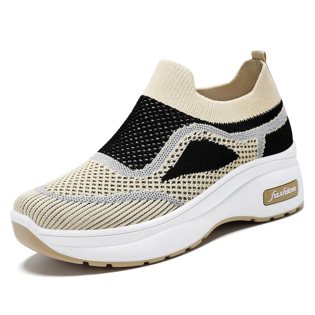 Breathable beige and black engineered knit slip-on sneakers for women, featuring a white platform sole with a &