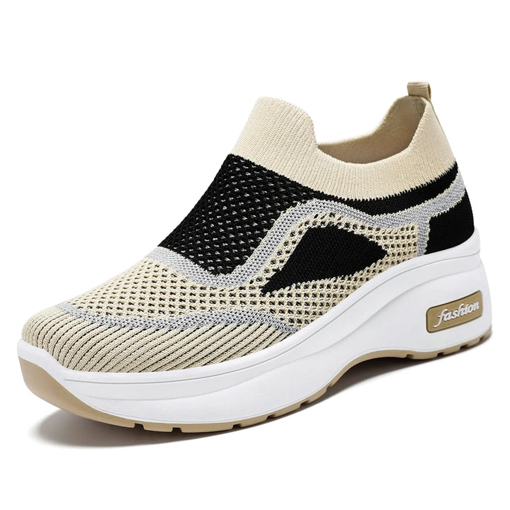 Breathable beige and black engineered knit slip-on sneakers for women, featuring a white platform sole with a &