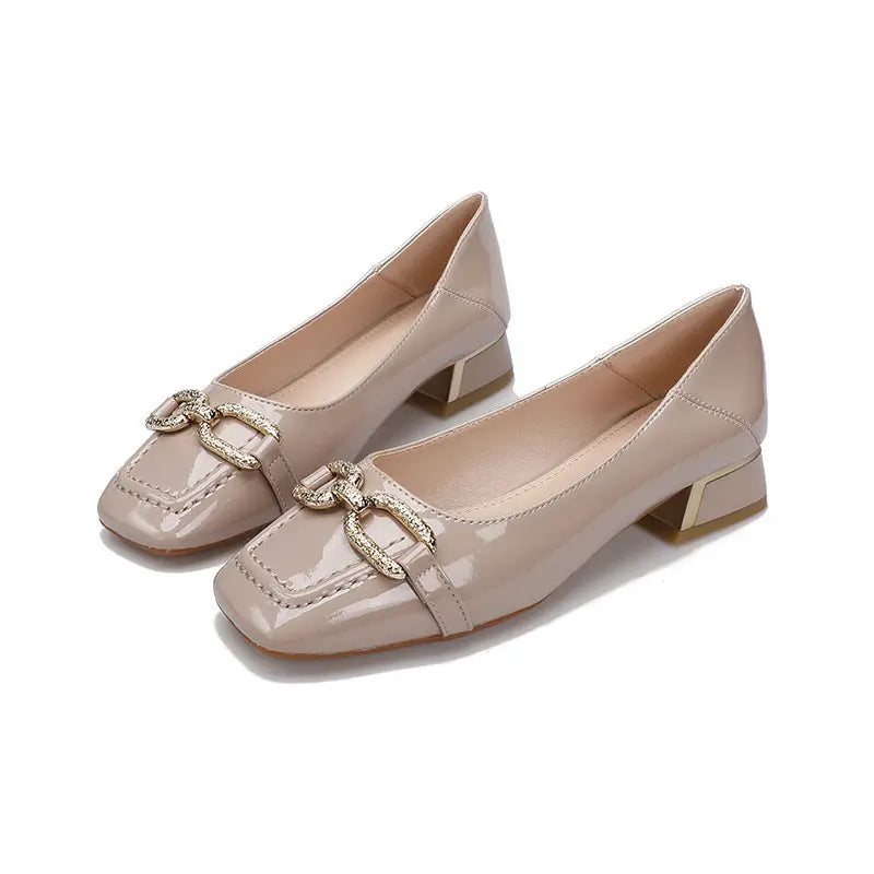 Pair of elegant beige patent leather pumps with a chic square toe, decorative gold buckle embellishment, and a stable block heel, shown from a front-three-quarter angle.