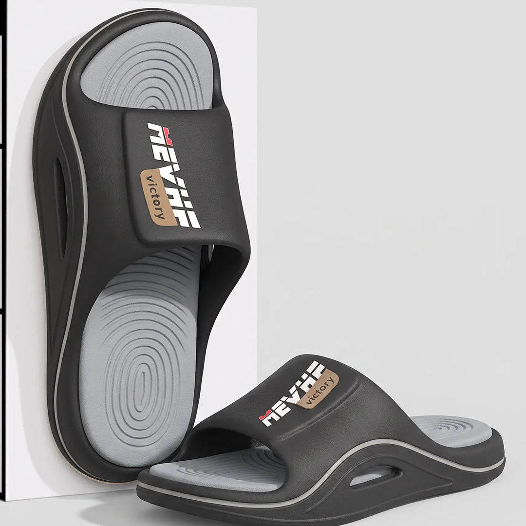 Black EVA slide sandal with a thick, sculpted sole and a textured wave-patterned footbed, featuring a wide strap with a &