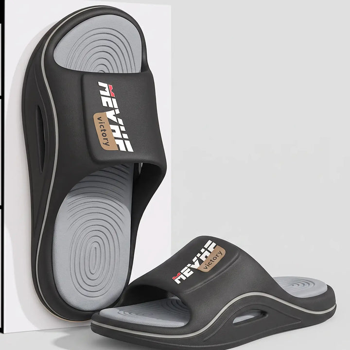 Black EVA slide sandal with a thick, sculpted sole and a textured wave-patterned footbed, featuring a wide strap with a &