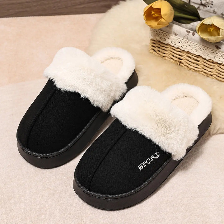 Black Vyxen mule slippers with plush white faux fur trim and a small embroidered &