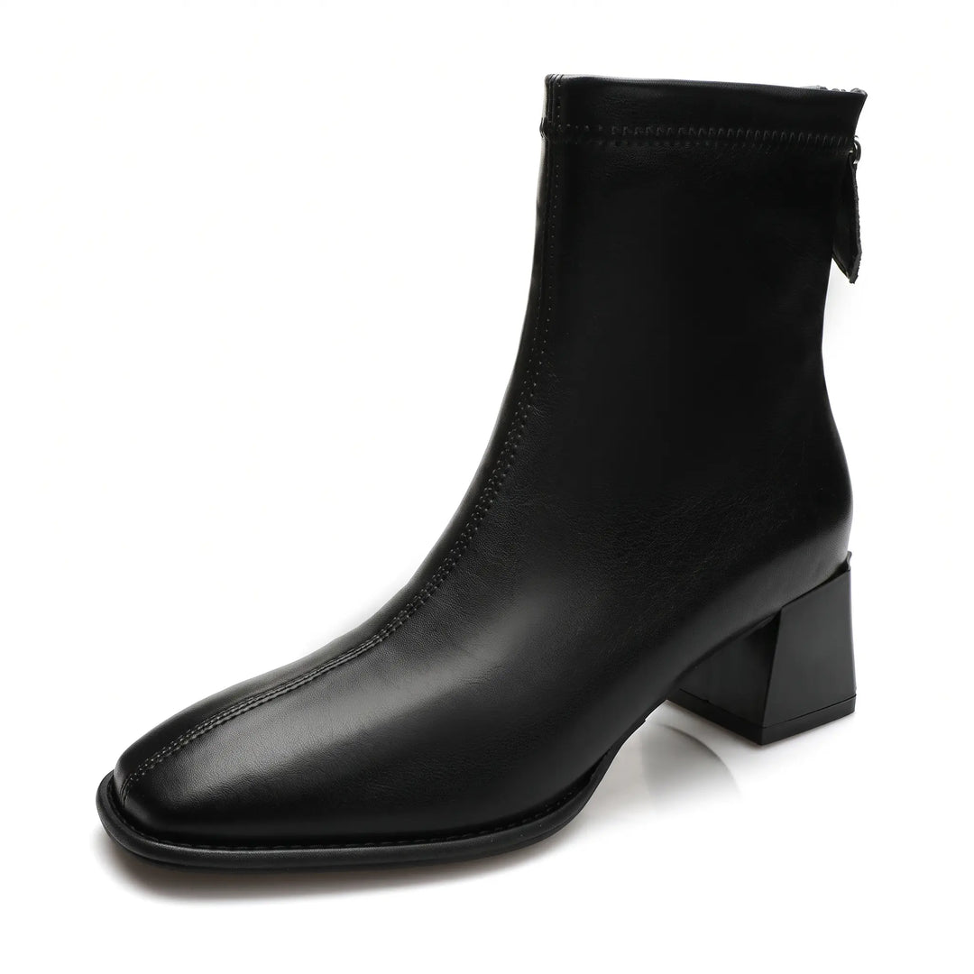 Black faux leather ankle boot featuring a square toe, block heel, and rear zipper closure, with a graphic indicating it is fleece-lined.