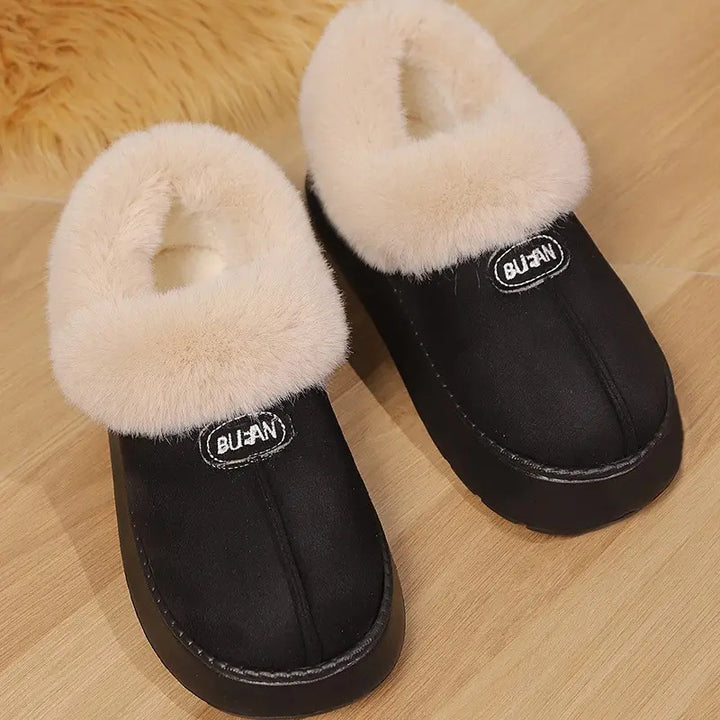 Black mule slippers with plush light beige faux fur lining and a thick EVA platform sole, featuring an embroidered BUAN logo patch on the vamp.