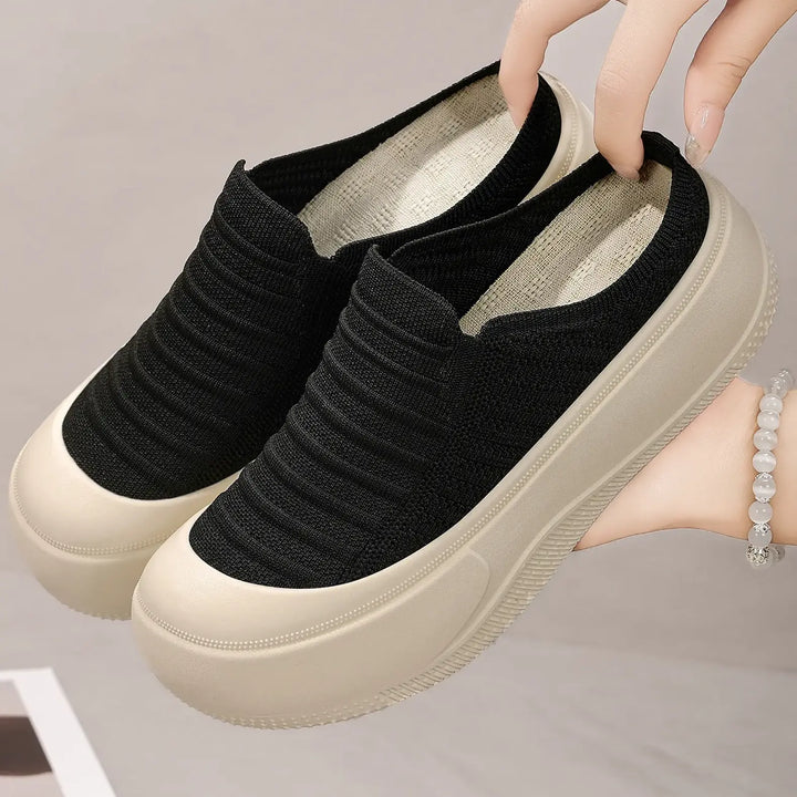 Black Vimera casual platform slip-on mules featuring a finely ribbed knit upper and a chunky, light beige platform sole, shown from a three-quarter angle.