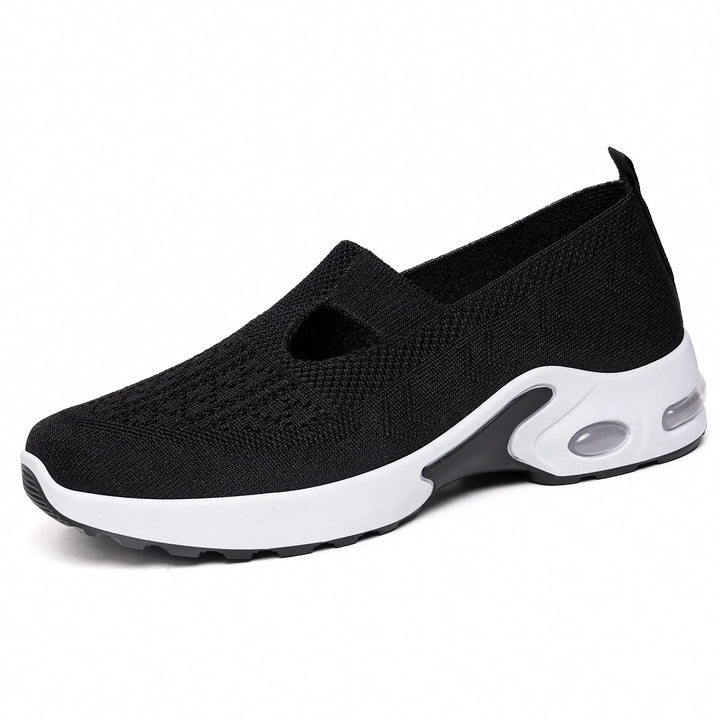 Black breathable knit slip-on sneaker with a white midsole featuring a visible translucent air cushion bubble at the heel.