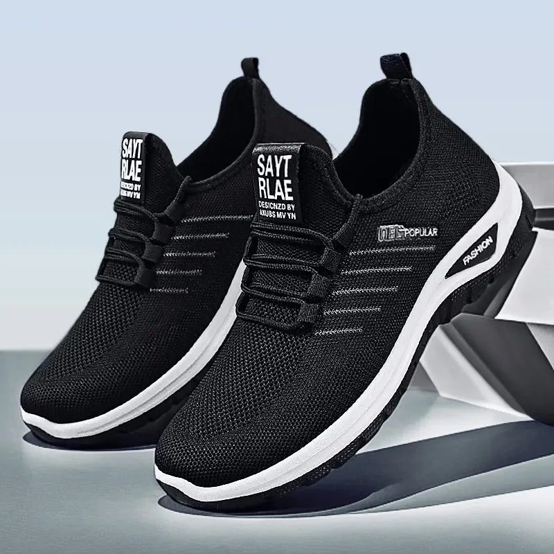 Black lightweight breathable knit slip-on sneakers with white midsole stripe featuring &