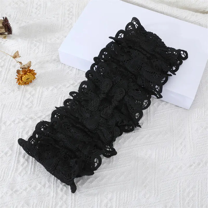 Black floral lace cummerbund belt with wide satin ribbon ties, showcased on a studio background with decorative elements.