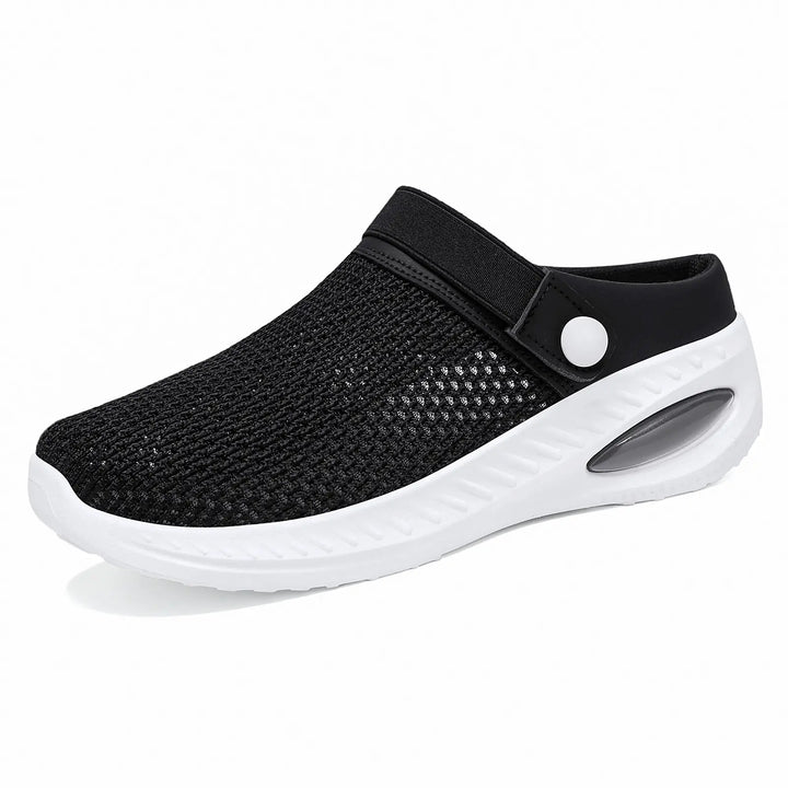 Black breathable mesh slip-on clogs for women, featuring a comfortable air cushion sole, adjustable strap with button detail, and a lightweight mule design.