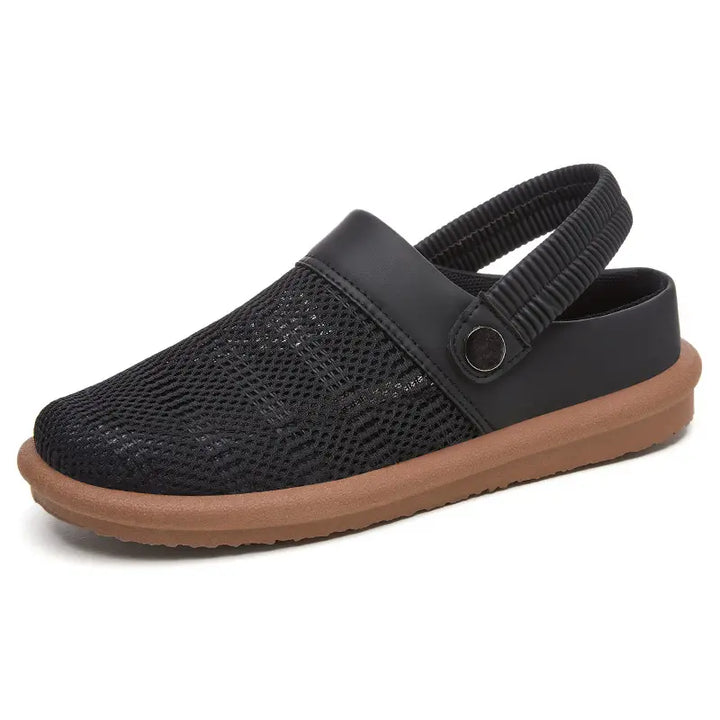 Black breathable mesh slip-on mules with a comfortable elasticated heel strap and a flat brown rubber sole.
