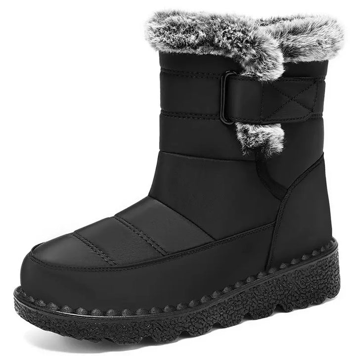 Black quilted mid-calf winter boot featuring plush faux fur trim, an adjustable side strap with a matte buckle, and a deep lugged rubber sole, presented on a clean white background.