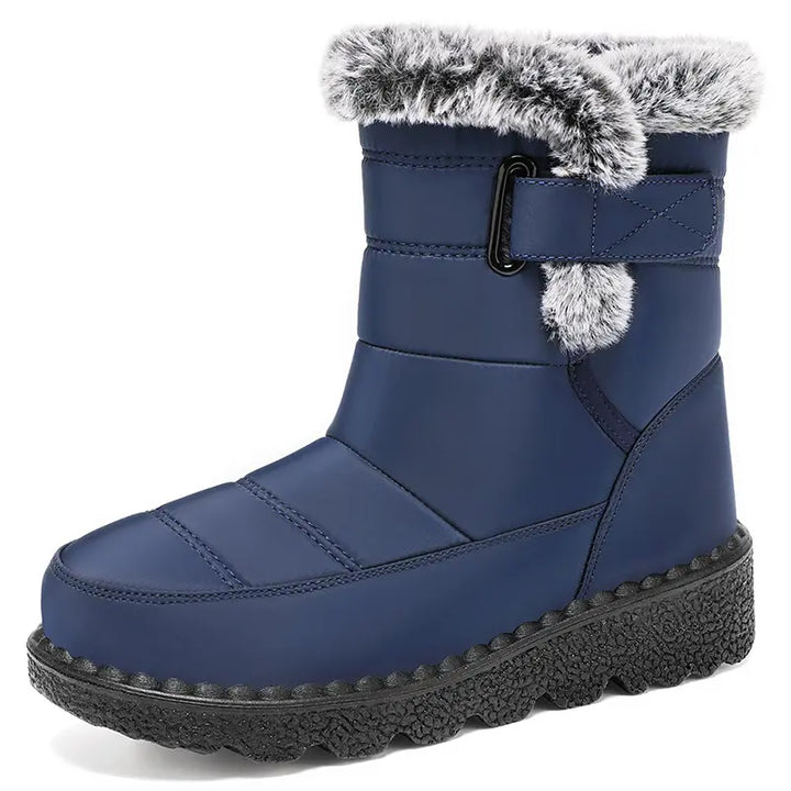 Blue quilted mid-calf winter boots featuring a cozy faux fur trim, an adjustable side strap with a buckle, and a durable lugged rubber sole for warmth and traction.