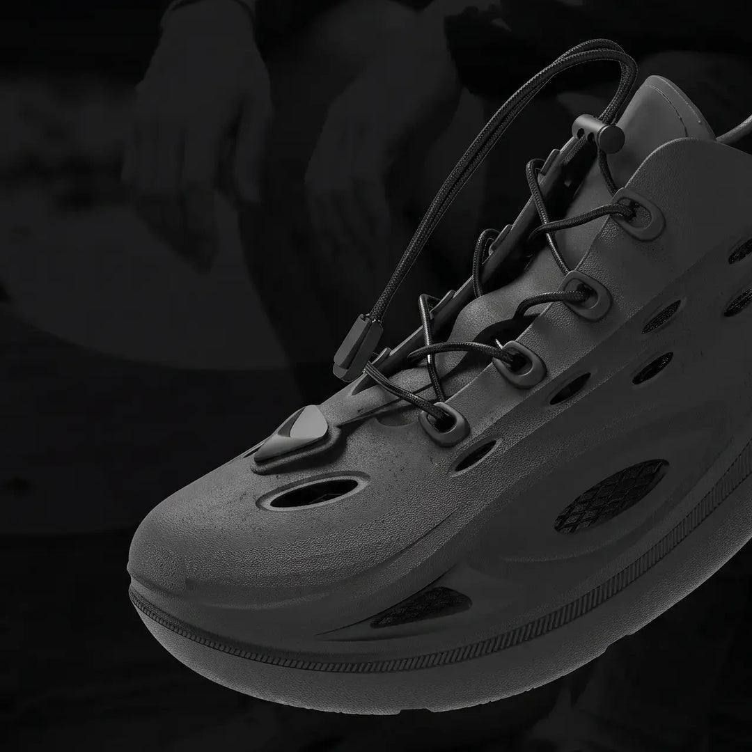 A pair of Brakko athletic slides in Phantom Black, shown from a three-quarter view with bungee laces and a sculpted sole.