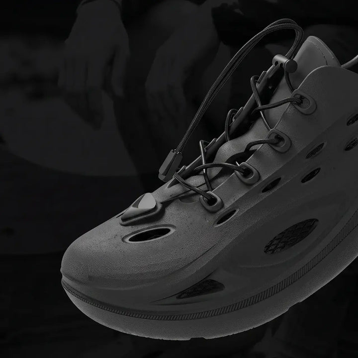 A pair of Brakko athletic slides in Phantom Black, shown from a three-quarter view with bungee laces and a sculpted sole.