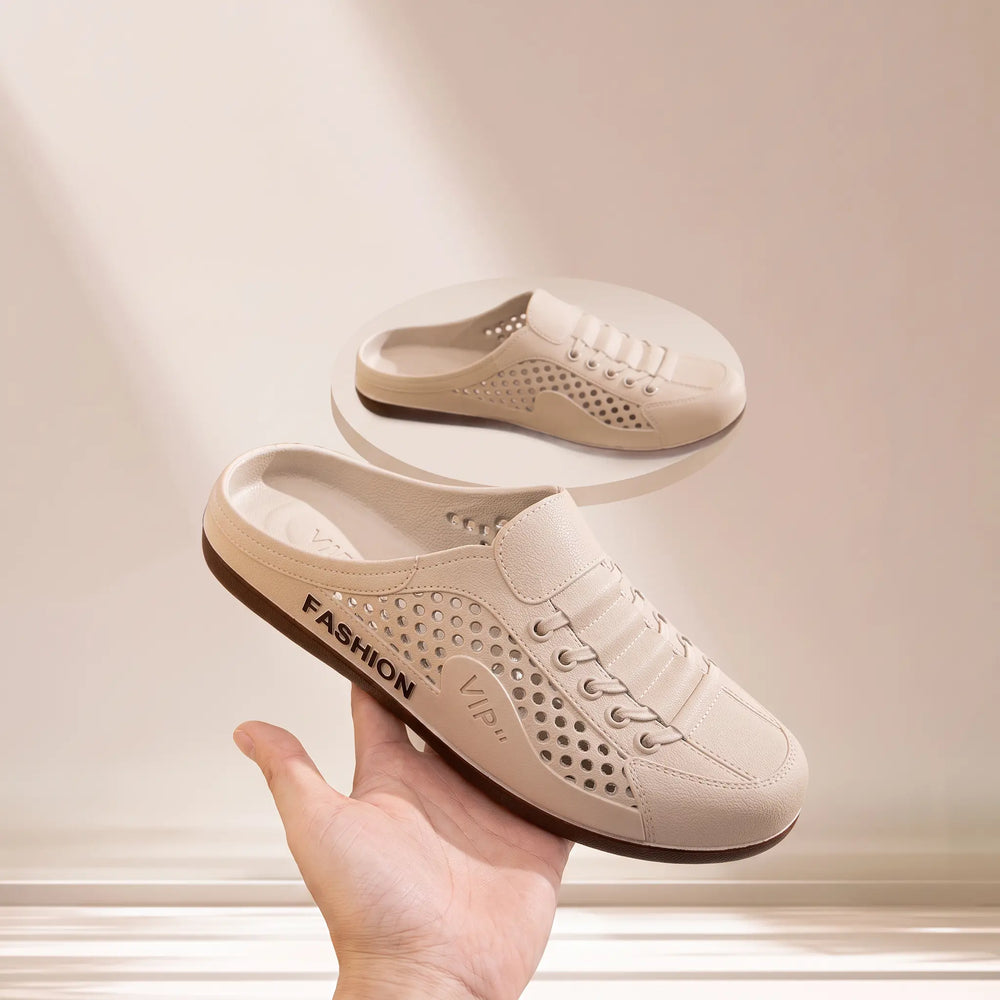 Pair of light beige breathable clogs with perforated detailing and faux lace-up design, shown with one shoe held by a hand. Features 'FASHION' and 'VIP' branding.