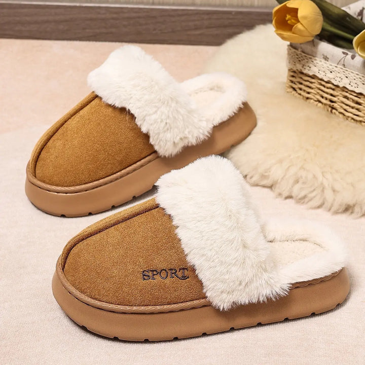 Brown mule slippers featuring a plush white faux fur trim, suede-effect upper, and an embroidered &