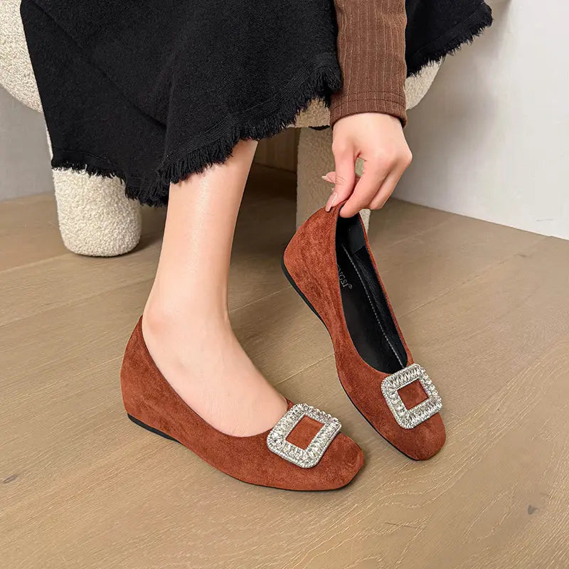 Brown suede slip-on wedge flats with a rounded-square toe, adorned with a large, sparkling crystal-embellished square buckle on the vamp.