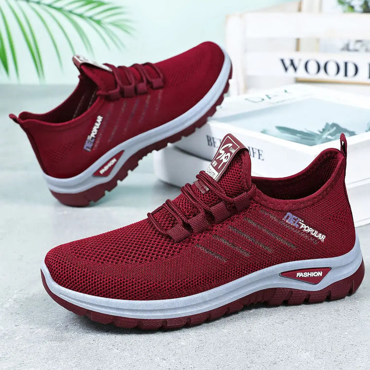 Pair of burgundy engineered knit sneakers shown from a three-quarter side view, featuring a white midsole stripe with &