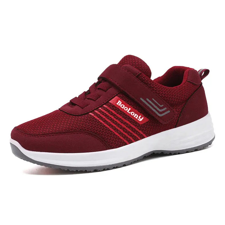 Burgundy mesh walking sneaker with a hook-and-loop strap, decorative laces, and reflective silver-grey stripes on the side. Features a white midsole and grey rubber outsole.