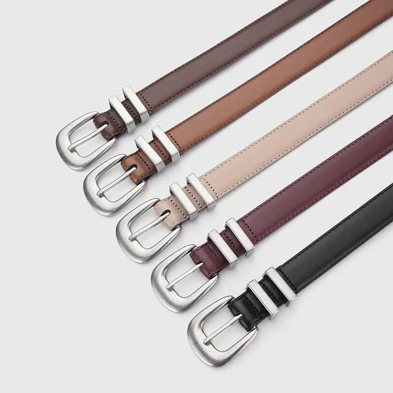 Multiple Drejka classic leather belts in black, Angola Red, Khaki, Coffee, and Brown hues, featuring antiqued silver Western buckles and dual-slot keepers, laid flat on a white background.