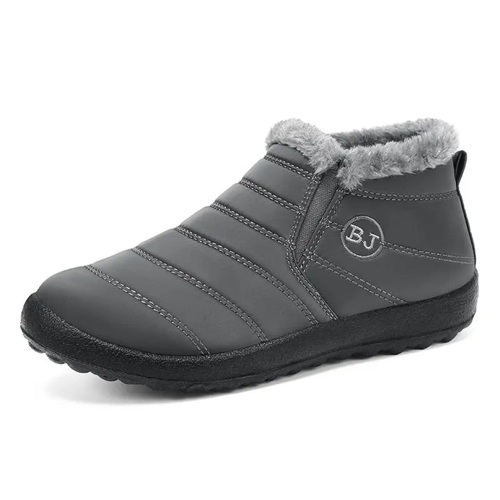 Faelan unisex matte black quilted nylon waterproof winter ankle boots with grey faux fur lining and elasticated side gore panels, shown in a front-three-quarter view.