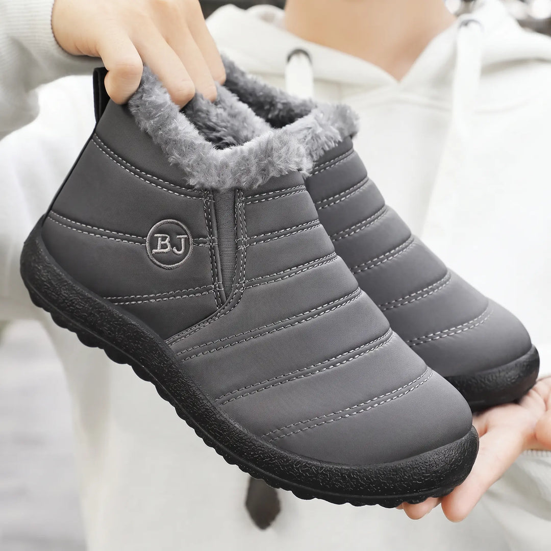Grey Faelan waterproof winter ankle boots featuring a plush faux fur lining, quilted nylon upper, elasticated side panels, and a black rubber sole.