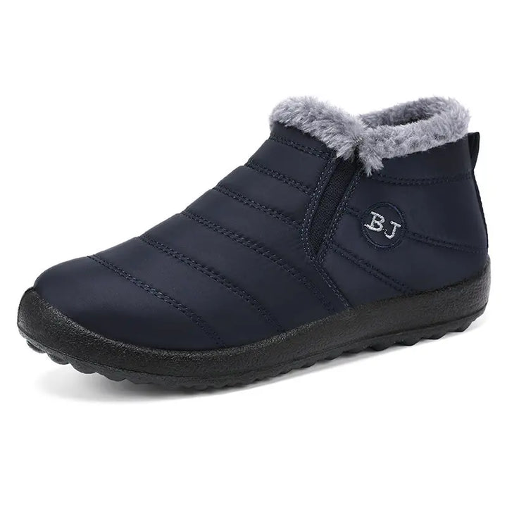 Faelan navy blue waterproof winter ankle boots featuring a quilted nylon upper, plush grey faux fur lining, and easy slip-on side gore panels with a subtle &