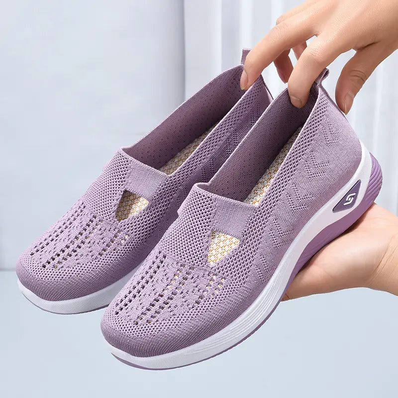 Lavender Faelan women's breathable knit mesh slip-on loafers shown from a three-quarter angle, featuring a geometric zig-zag pattern and a cushioned white and purple sole.