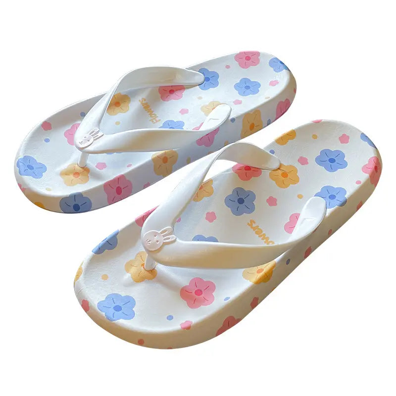 White platform flip-flops adorned with a playful pastel floral print and a cute bunny charm on the toe post.