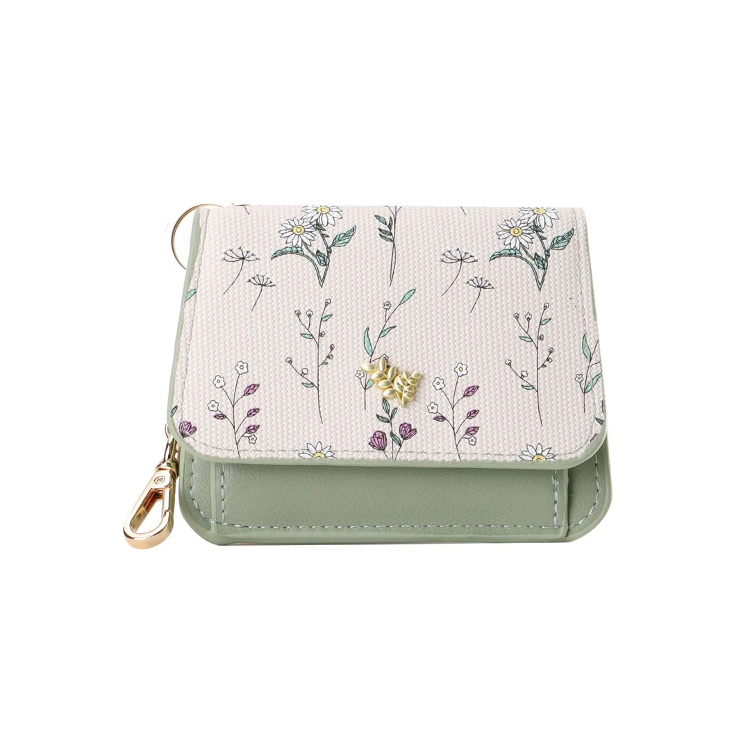 Compact tri-fold wallet featuring a delicate floral print on the flap, pastel green PU leather, and gold-tone hardware with a snap closure and attached keychain.