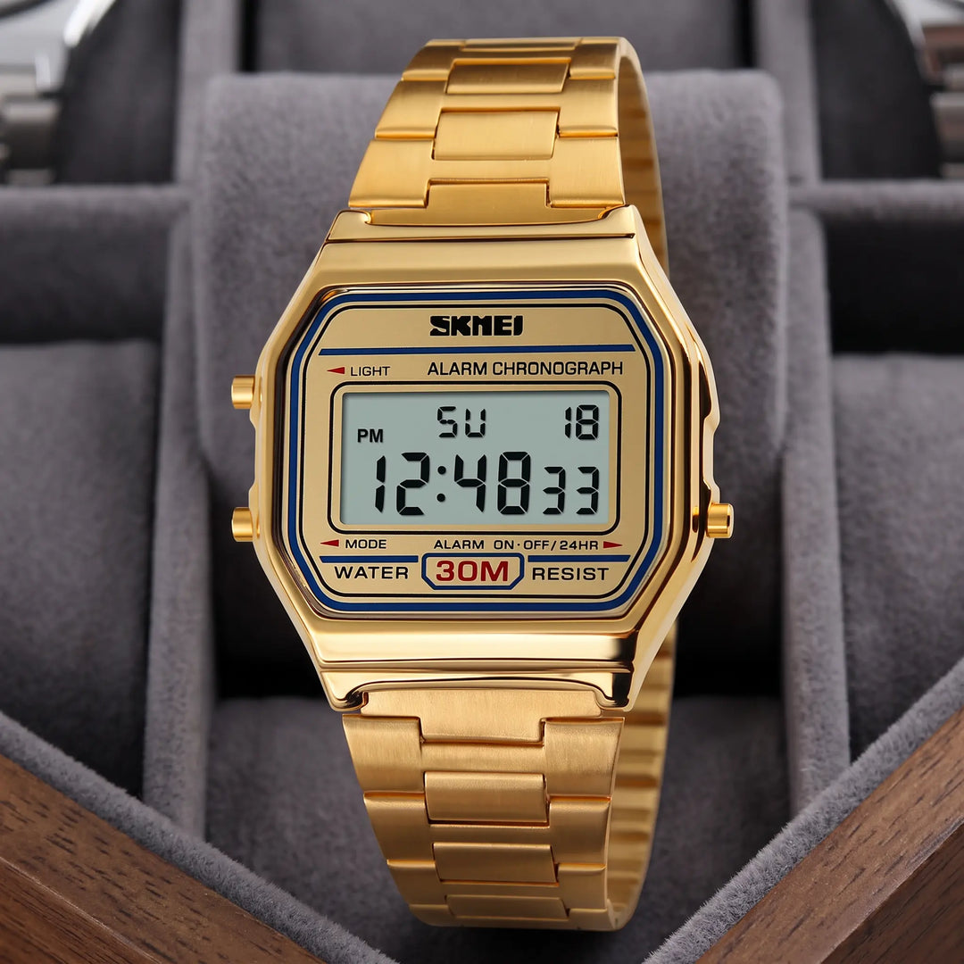 Gold-toned retro digital watch with a polished stainless steel case and link bracelet, featuring a blue digital display, push buttons, and functional text labels.