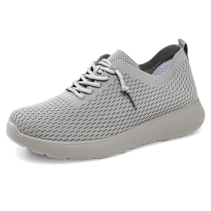 Grey lightweight breathable engineered knit trainers for men, featuring a sock-like fit, lace-up closure, and a sculpted EVA sole. Modern athleisure footwear.