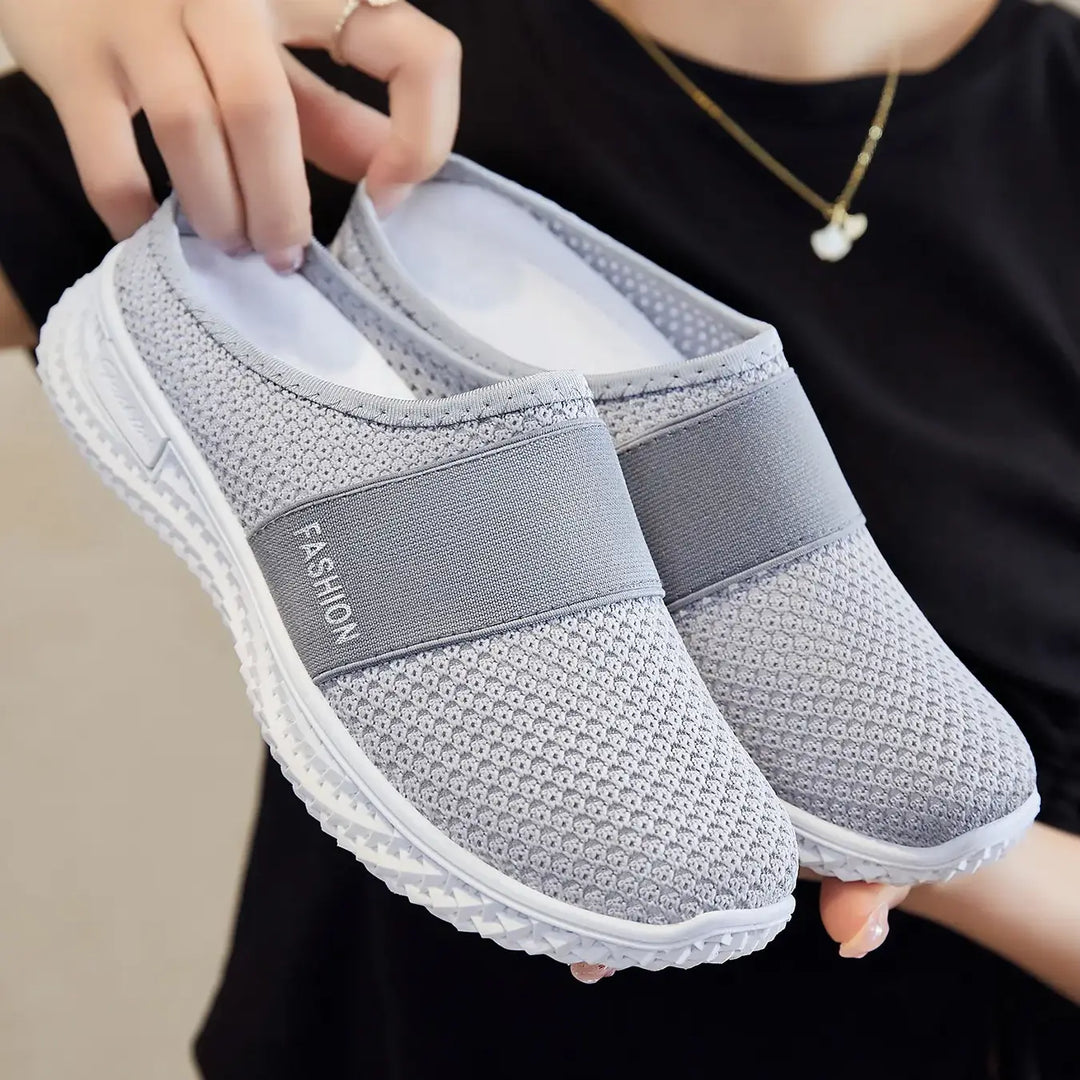 Pair of grey breathable mesh slip-on trainers with a contrasting elasticated band imprinted with &