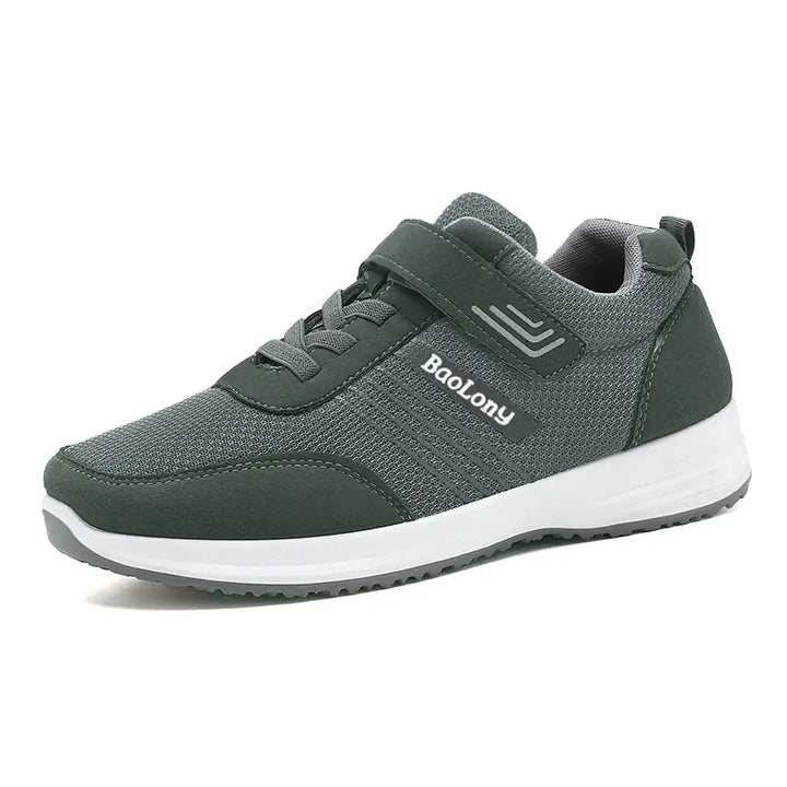 Dark grey breathable mesh sneaker with a hook-and-loop strap and decorative laces, featuring a white midsole and grey outsole, shown from a three-quarter angle on a white background.
