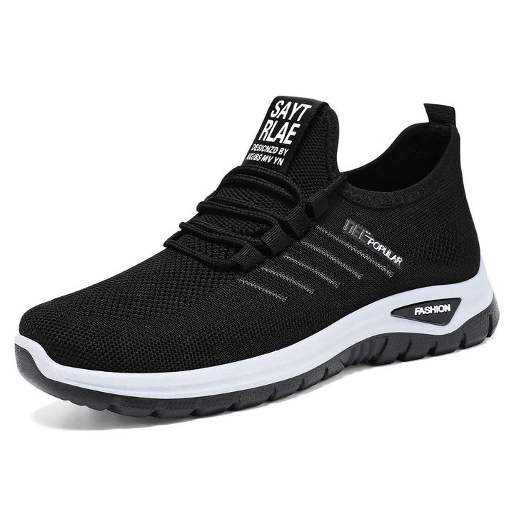 Front three-quarter view of a black breathable mesh Gryphos sneaker with a white midsole and dark outsole, featuring elastic laces and &