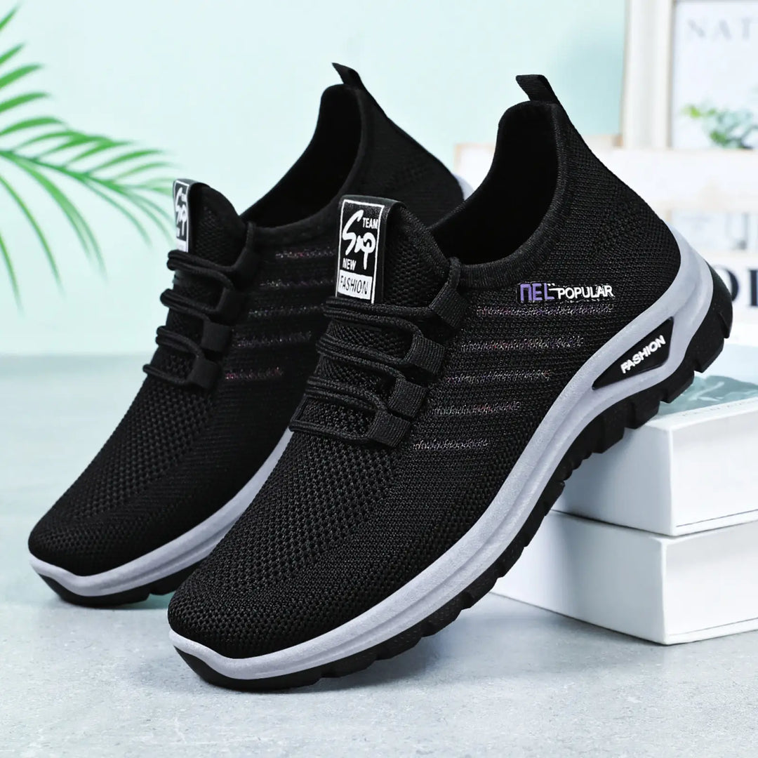 Pair of black Gryphos breathable mesh sneakers with white midsoles and dark outsoles, shown from a three-quarter angle on a studio background.