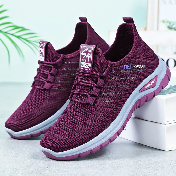Deep purple breathable mesh sneakers with a contrasting white midsole and a dark grey outsole, shown in a three-quarter front view.