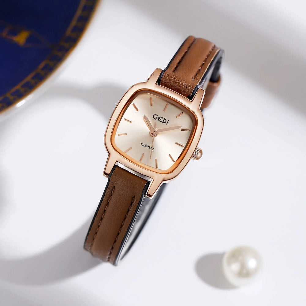 Gyrion rose gold women's square-cushion quartz watch with a champagne sunray dial and a brown genuine leather strap. The timepiece is shown at a three-quarter angle on a clean, softly lit studio background with subtle decorative elements.