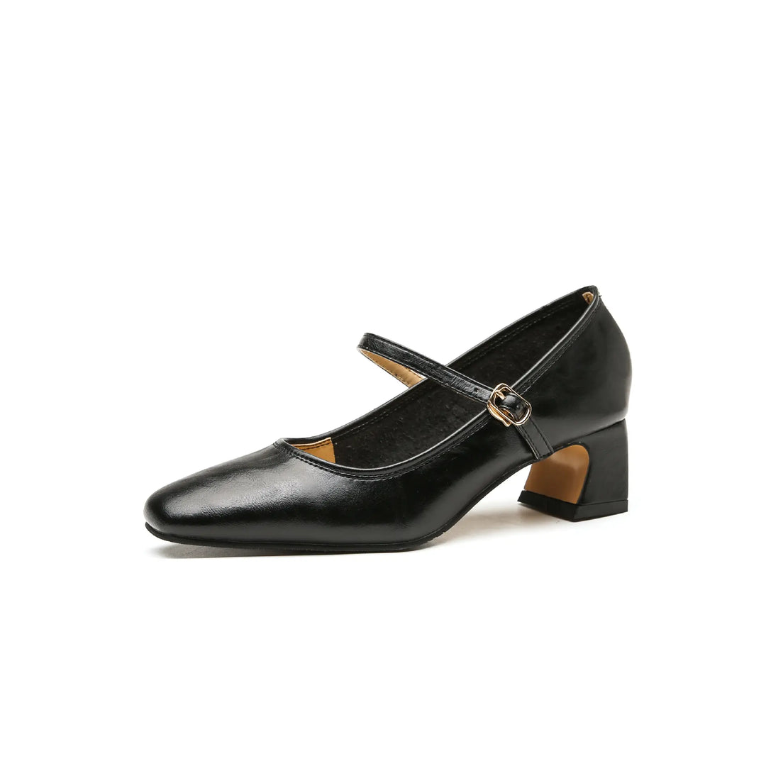 Black faux leather Mary Jane heels featuring a chic square toe, a delicate single ankle strap with a polished gold-tone buckle, and a comfortable medium block heel. The shoe is presented from a three-quarter angle on a clean white background.