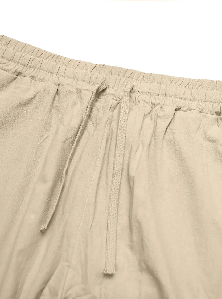 Close-up view of relaxed-fit Kaelan linen-blend trousers in classic khaki, showcasing the elasticated waistband and adjustable drawstring detail.
