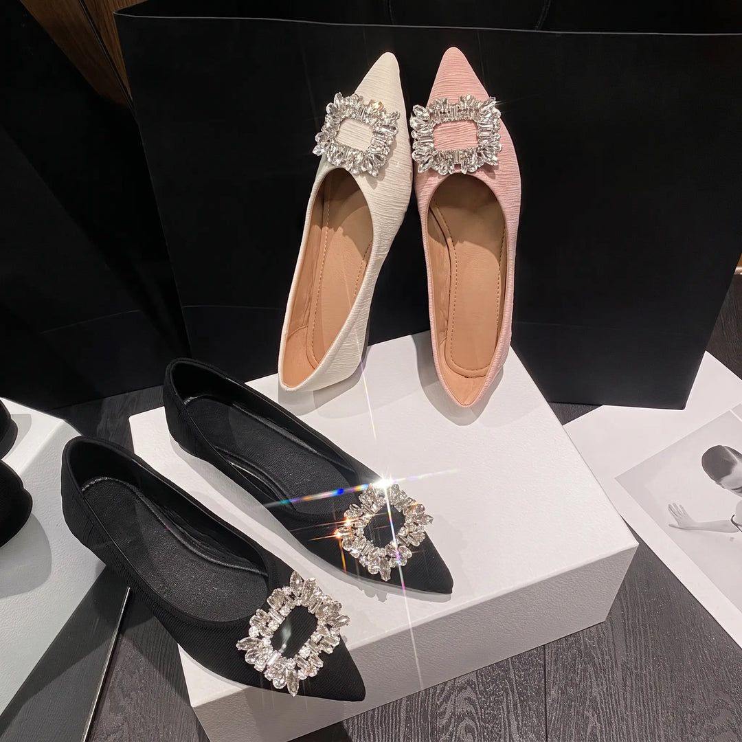 Kaelan Embellished Pointed Flats in black, pink, and cream, showcasing sparkling rhinestone square buckle details from a top-down view.