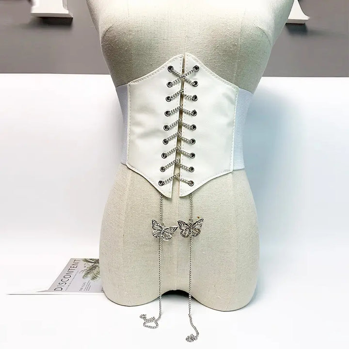 White Kaelan corset belt with silver chain lace-up and dangling butterfly charms, displayed on a mannequin front view.